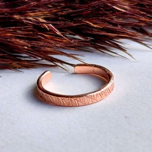 Handcrafted copper ear cuff with a tactile textured finish and organic hammered surface