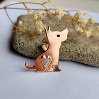 Angled view of the handcrafted copper dog brooch with a sterling silver heart