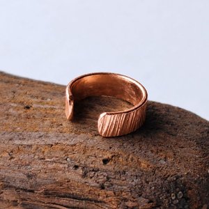 Copper hammered ear cuff photographed from the side to show its curved open design