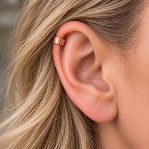 Hammered copper ear cuff shown being worn on the upper helix of a fair-haired woman's ear
