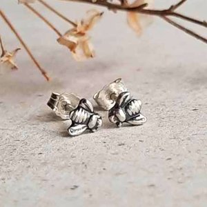Fine silver bee stud earrings showing the detailed bee design and sterling silver fasteners