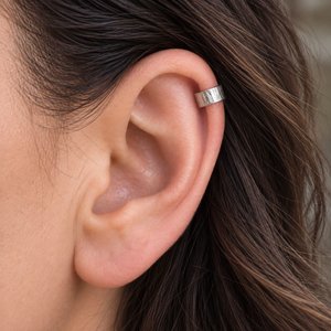 Hammered sterling silver ear cuff shown being worn on the upper helix of a woman's ear