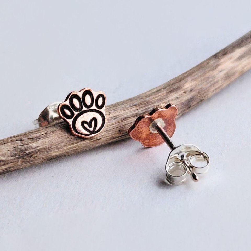 Handmade copper paw print stud earrings showing the front and back with sterling silver butterfly backs