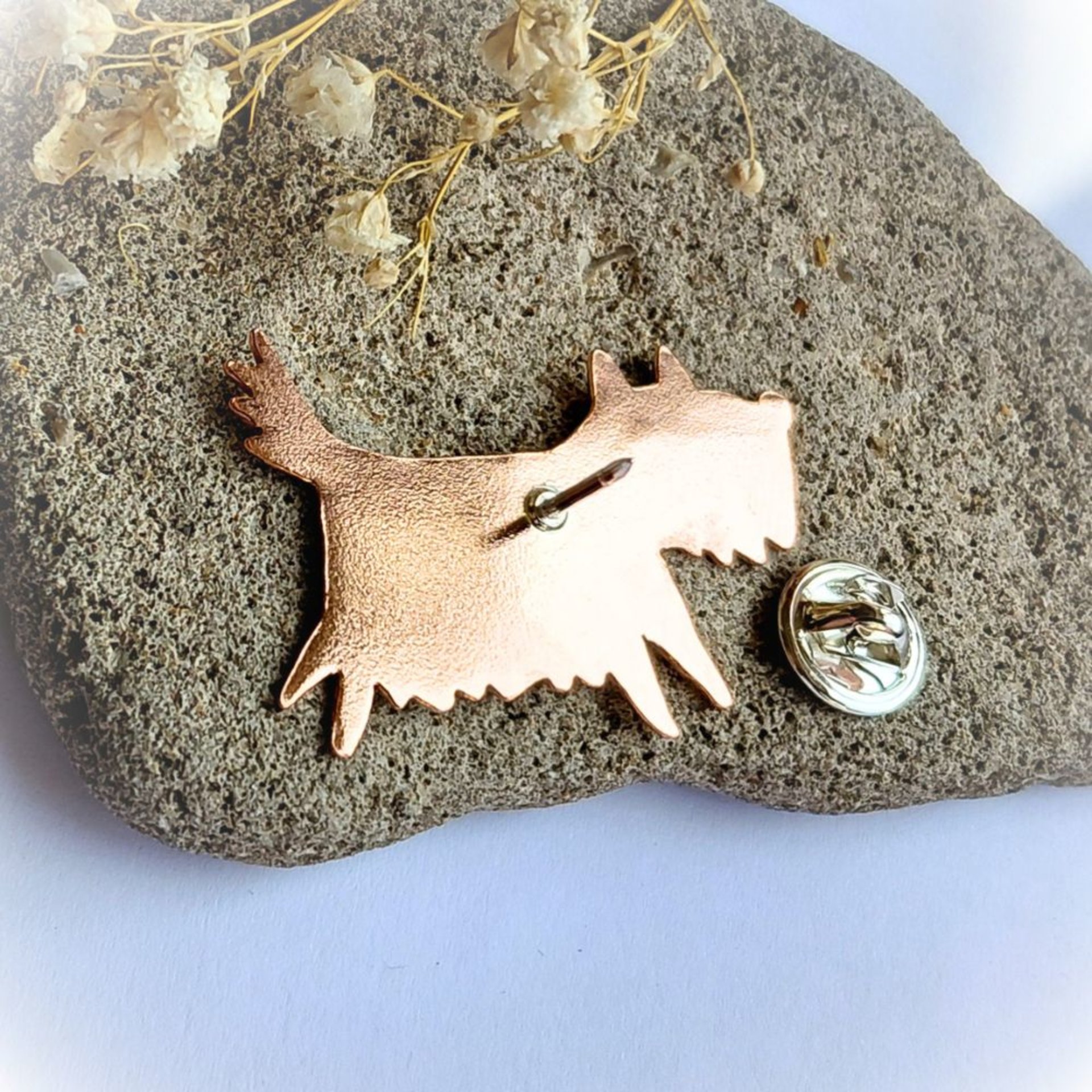 Rear view of the handcrafted copper scruffy terrier dog brooch with the brooch pin open