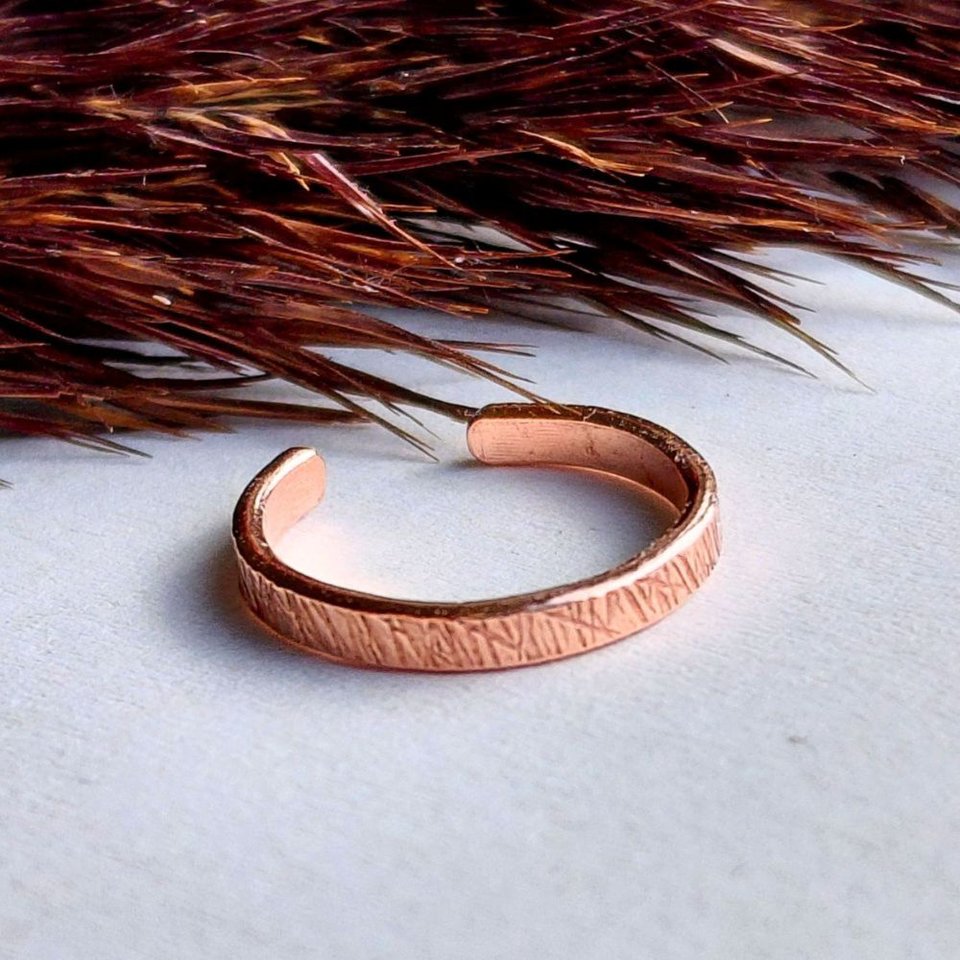 Handcrafted copper ear cuff with a tactile textured finish and organic hammered surface