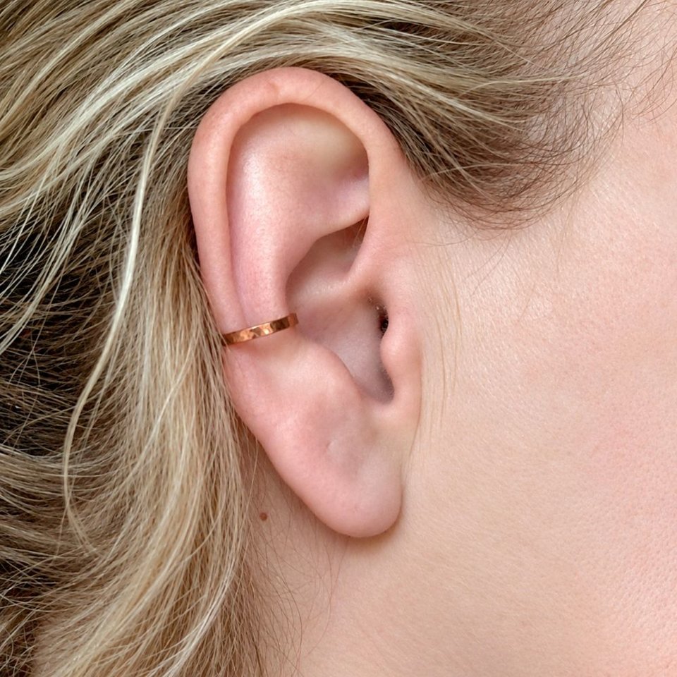 Handcrafted no-piercing copper ear cuff worn comfortably around the conch of the ear