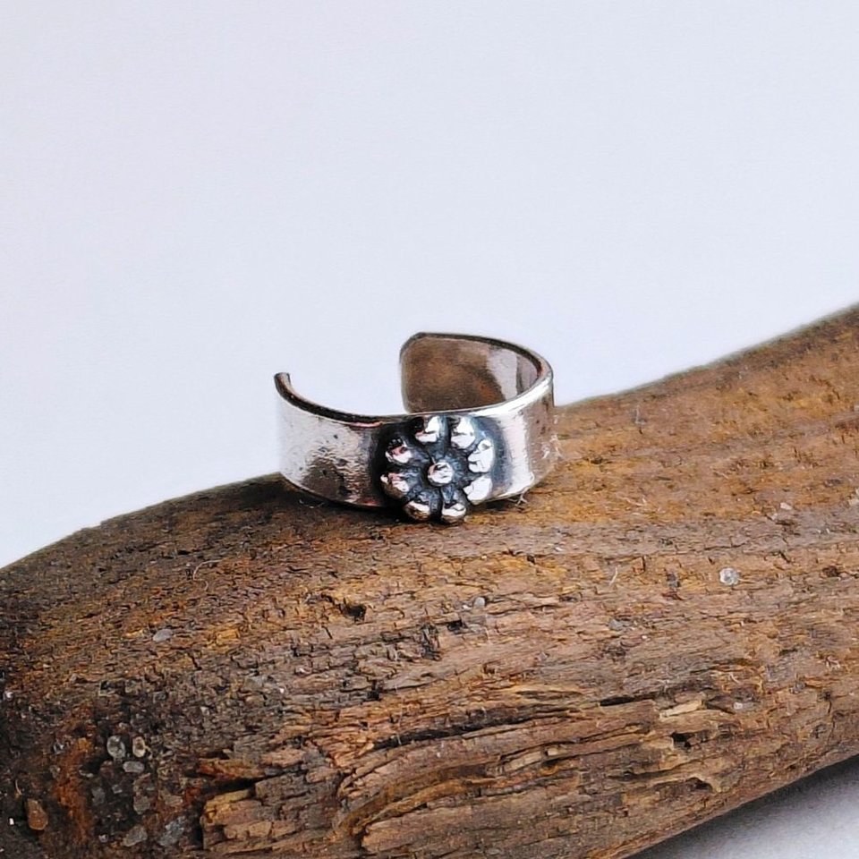 Handmade sterling silver no-piercing helix cuff featuring a tiny fine silver daisy flower