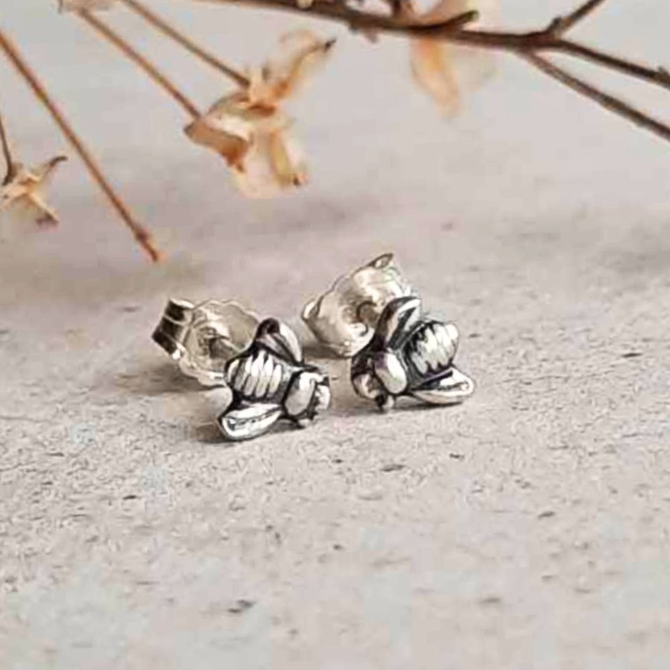 Fine silver bee stud earrings showing the detailed bee design and sterling silver fasteners