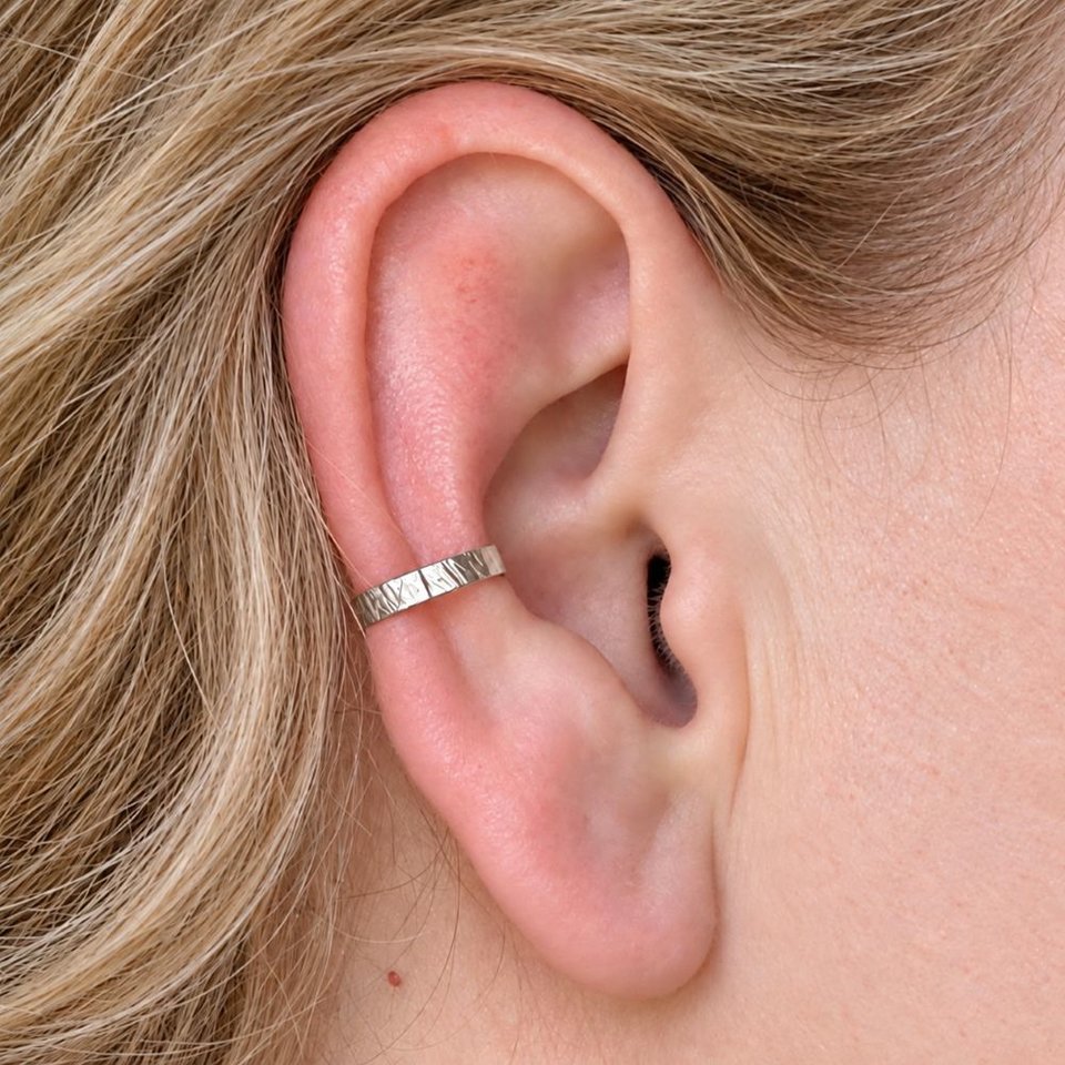 Hammered sterling silver ear cuff shown being worn on the conch of a woman's ear