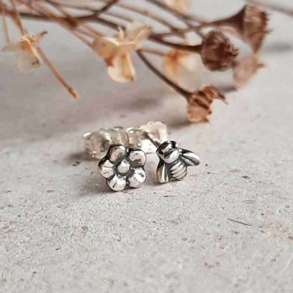 Silver bee and flower mismatched stud earrings shown from the front with sterling silver butterfly backs